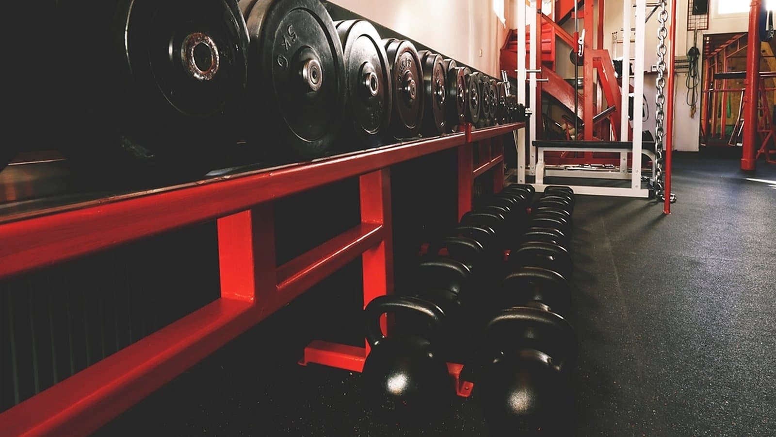 Strength training floor of a gym with racked plates and dumbbells, where footfall sets the unit economics